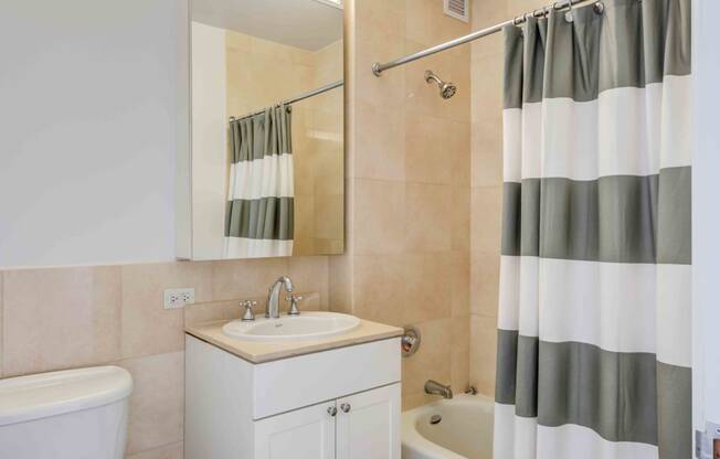 Model apartment bathroom with vanity and tub shower