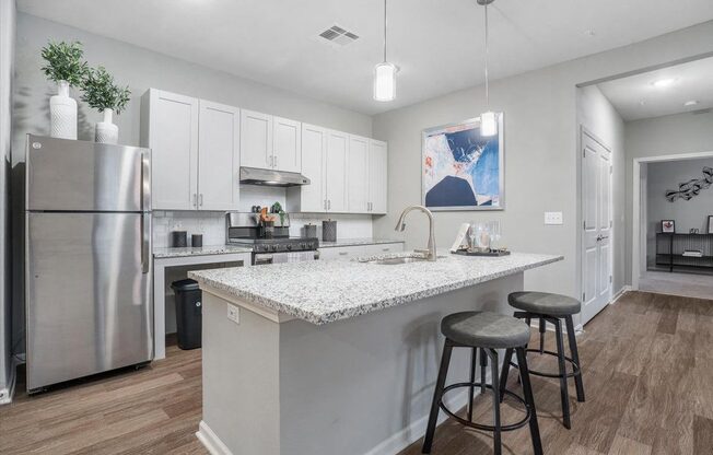 a kitchen with a counter top and a stainless steel refrigerator