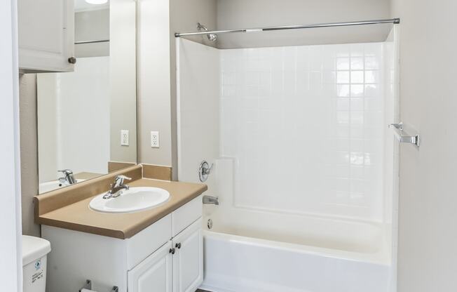 an empty bathroom with a sink toilet and shower