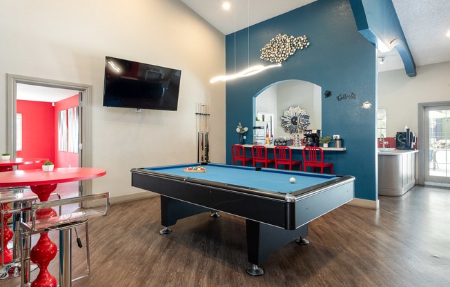 a game room with a pool table and a tv