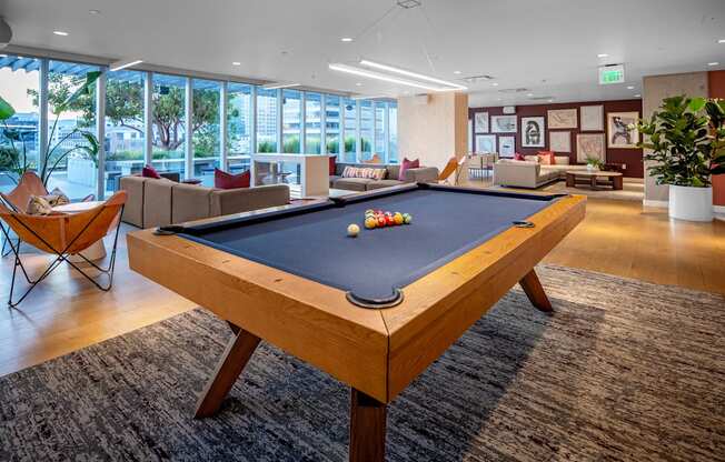 A pool table in a room with a view of the city.