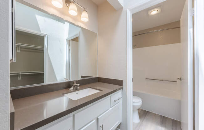 A bathroom with a sink, mirror, and toilet. at Harbor Pointe, Dana Point, CA