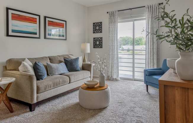 a living room with a couch and a door to a balcony