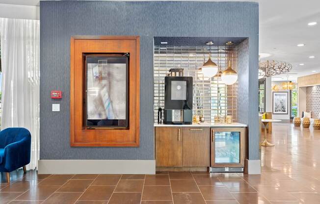 A reception area with a blue chair and a framed picture on the wall.