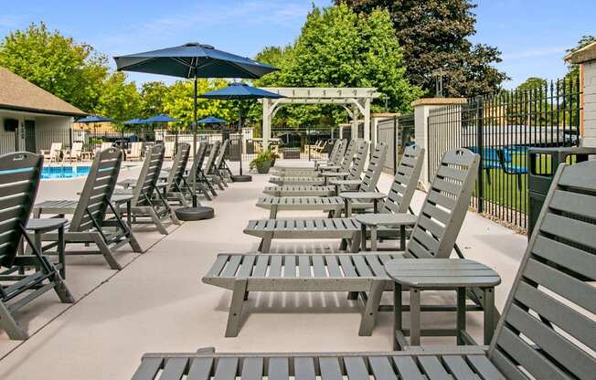 A poolside area with sun loungers and umbrellas.