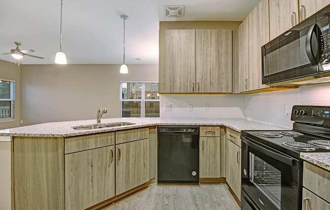 brand new interiors with black appliances and vinyl plank flooring, light wood cabinets and granite countertops at York Woods at Lake Murray Apartment Homes, Columbia