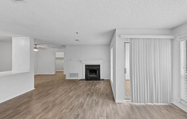 A spacious living room with a fireplace and hardwood floors.