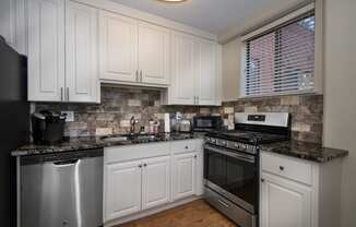 a kitchen with white cabinets and stainless steel appliances