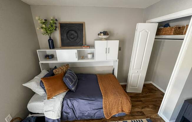 a bedroom with a bed and a shelf above it