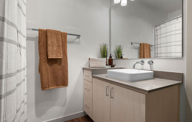 a bathroom with a sink and a shower and towels