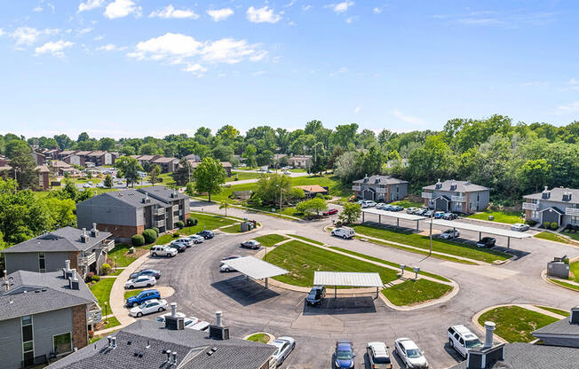 an aerial view of a neighborhood with cars parked on the street