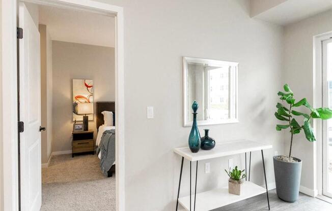A bedroom with a bed, nightstand, and a mirror on the wall.