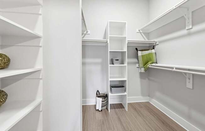 A white closet with shelves and a green pillow.