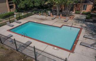 a pool with a fence around it and a building in the background