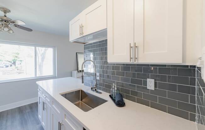 a kitchen with white cabinets and a sink