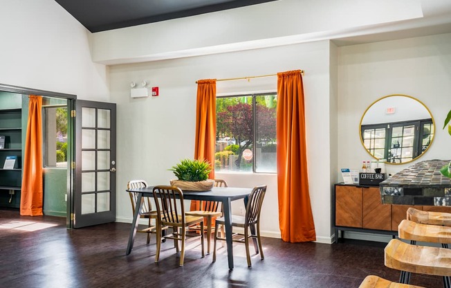 A dining room with a table and chairs.