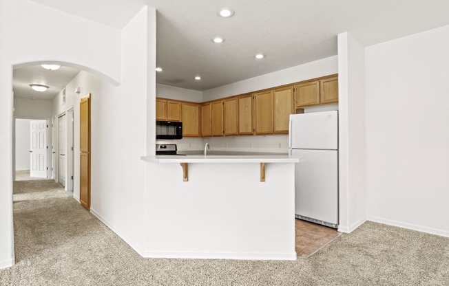 a kitchen with white walls and brown cabinets