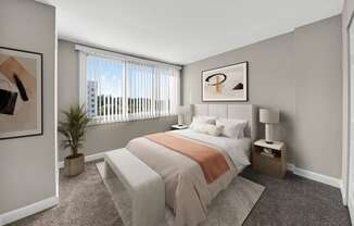 A bedroom with a bed, nightstand, and window.