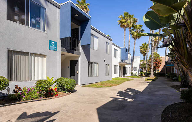 A sunny day at the G Street Apartments with a clear blue sky and palm trees.