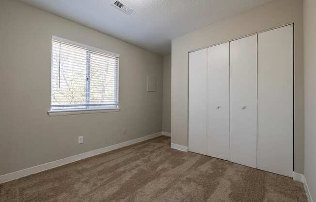 a bedroom with a closet and a window