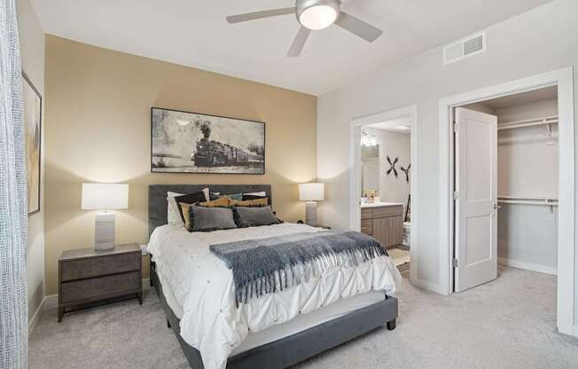 A bedroom with a bed, nightstands, and a painting on the wall.