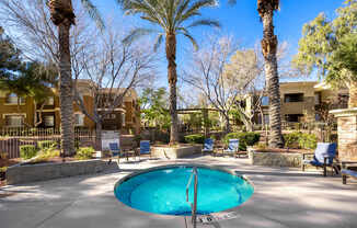 Spa surrounded by palm trees and chairs.