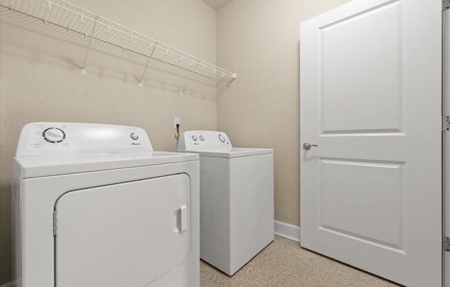 A white washing machine and dryer in a laundry room.