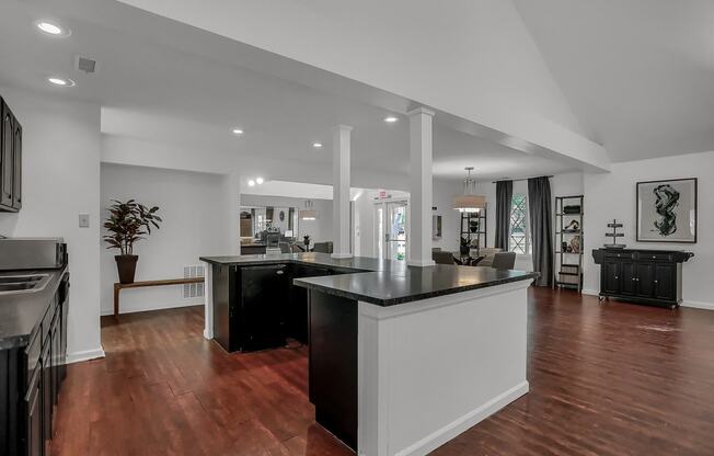 an open kitchen and lounge room with a large counter top in Greenwood Apartments clubhouse