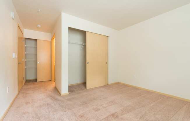 a bedroom with a closet and a carpeted floor