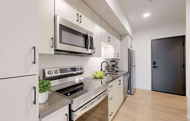 A modern kitchen with a stove, oven, microwave, and refrigerator.