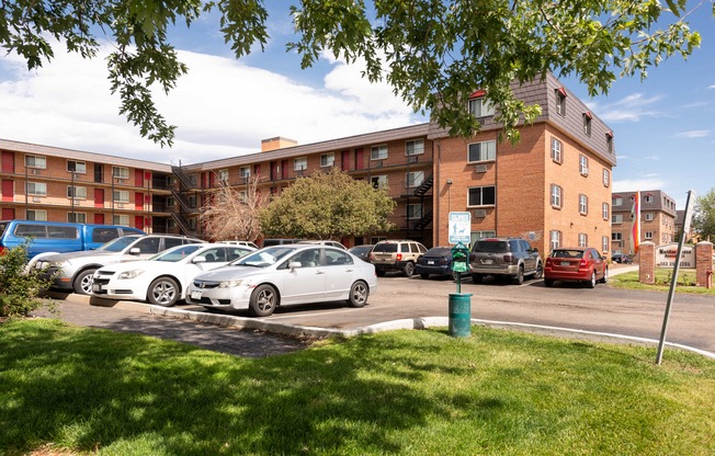 a parking lot with cars in front of an apartment building