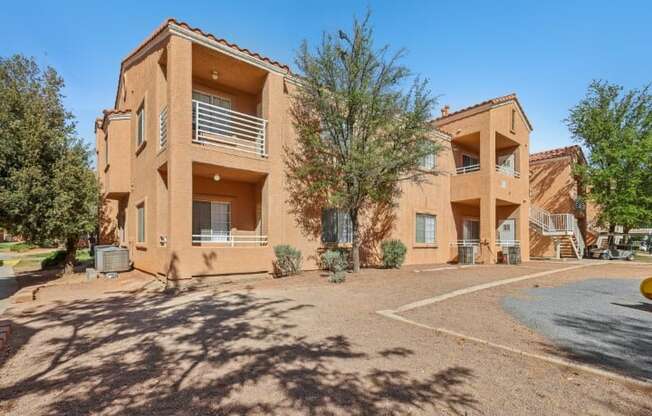 A building with a red roof and a parking lot in front.
