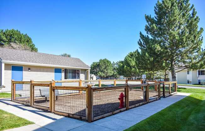 Gated dog park surrounded by sidewalk and green grass at Kirkwood Meadows, Pocatello, ID 83201