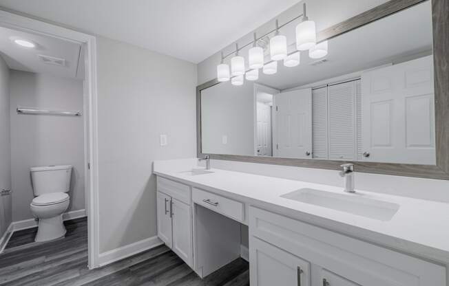 a bathroom with dual vanities, white countertops and cabinetrty