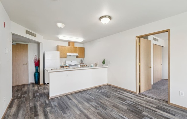 the living room and kitchen in a renovated apartment with wood flooring