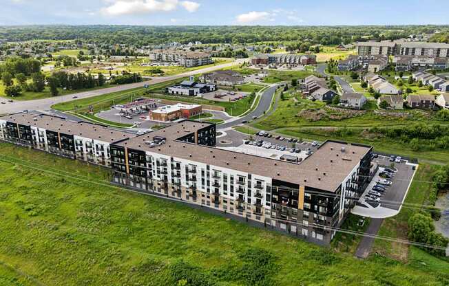 A large building complex with a parking lot in front.