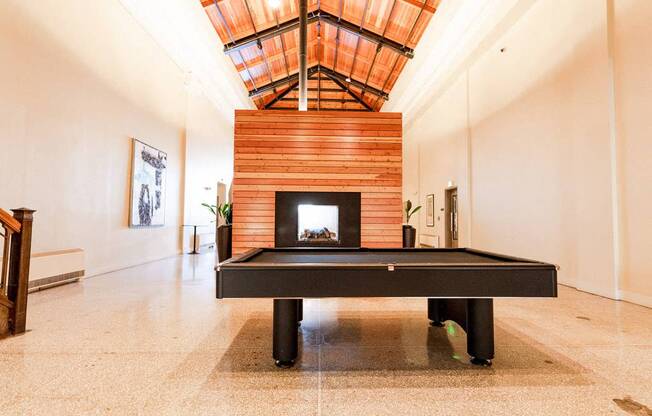 A room with a fireplace and a pool table at Addison on Fourth Apartments, Seattle, WA