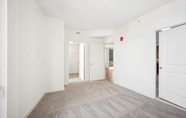 A hallway with a carpeted floor and white walls.