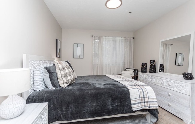 a bedroom with a bed and a dresser and a mirror