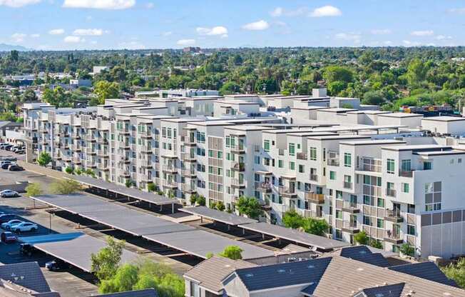 A large apartment complex with a parking lot in front.