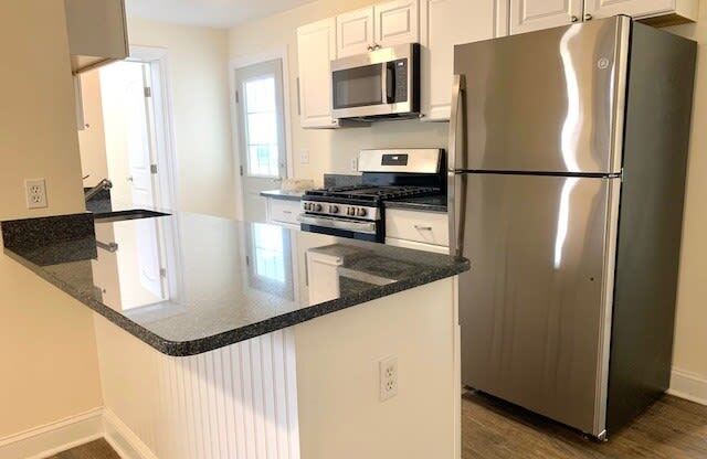 a kitchen with a stove a refrigerator and a microwave