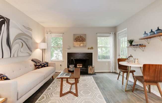 a living room with a couch table and chairs and a fireplace