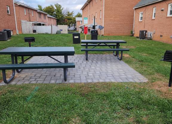 A green picnic table is in the middle of a grassy area.