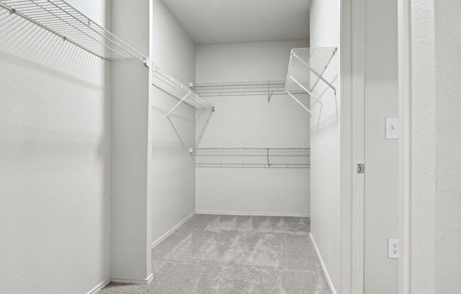 A white hallway with a carpeted floor and a door on the right.