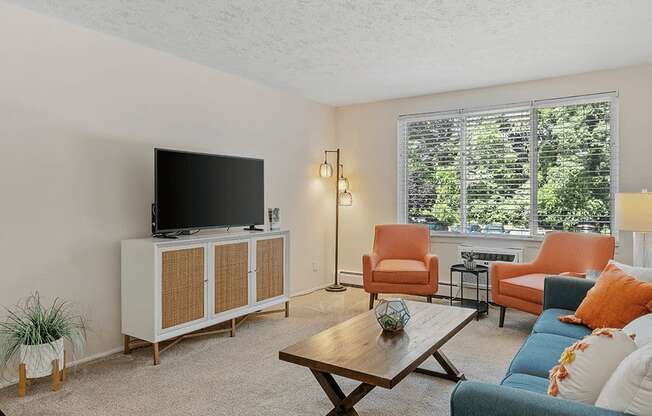 a living room with a couch and chair and a tv on top of a cabinet