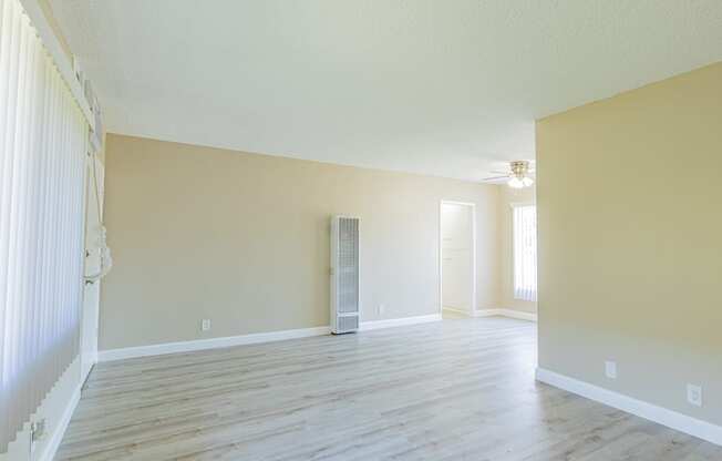 an empty living room with a hard wood floor and yellow walls