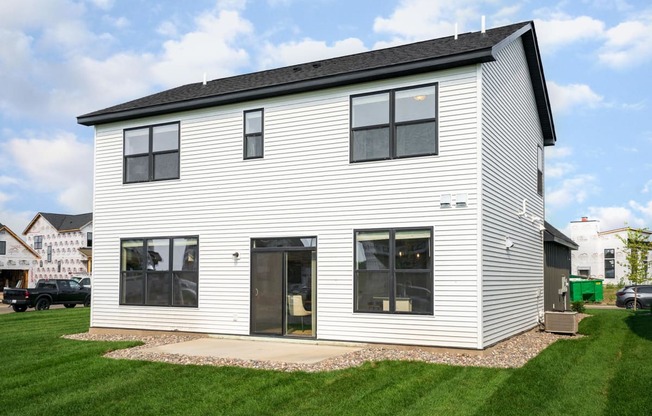 a home with white siding and a black roof