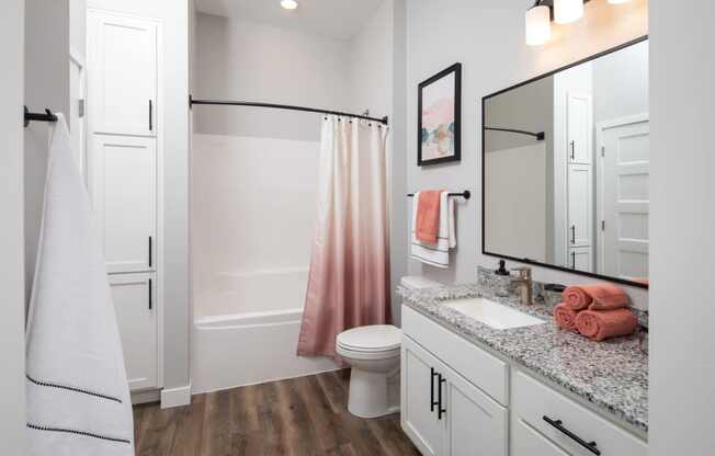 A bathroom with a toilet, sink, and shower.
