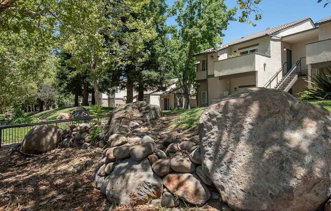 Stanford Heights apartments landscaping boulders and trees in front of a building