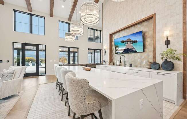 a large kitchen with a large marble counter top and chairs